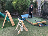 outdoor putter stand with personalized golf sign in the backyard, man holding scotty Cameron putter on perfect practice golf platform