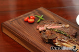 American wagyu beef on wooden steak board. rosemary, asparagus and cherry tomatoes garnish 